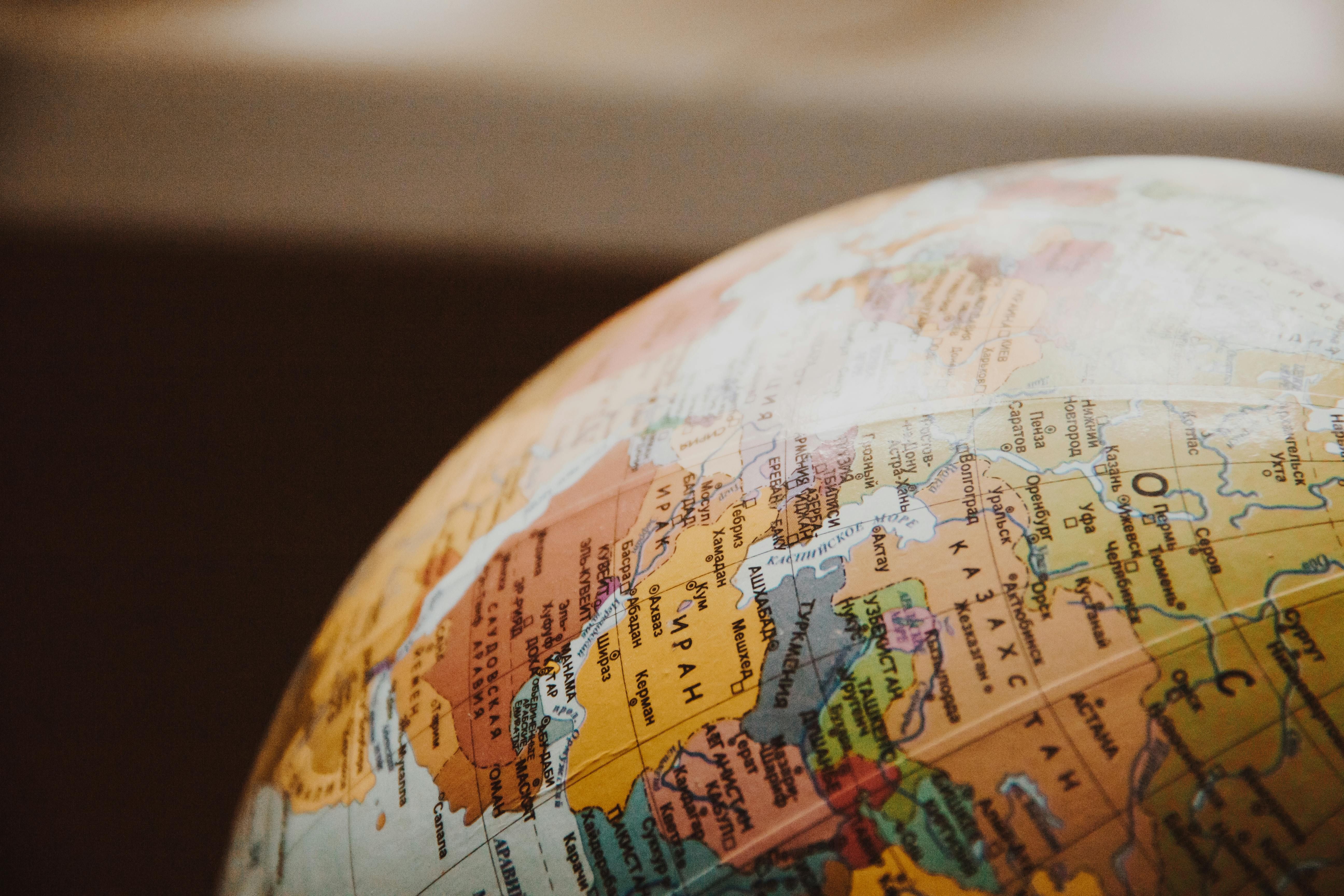 A minimalist globe icon with various country outlines. Two lines, one originating from inside the UK and another from outside, are converging on the UK, symbolising the ease of transferring funds from both UK and non-UK residents.